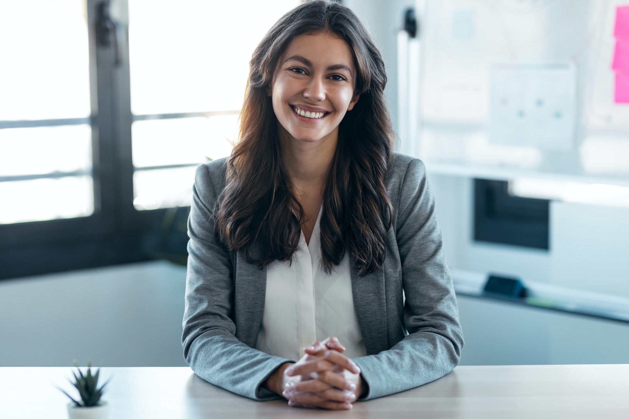 Confident business woman looking and speaking through the webcam while making a video conference